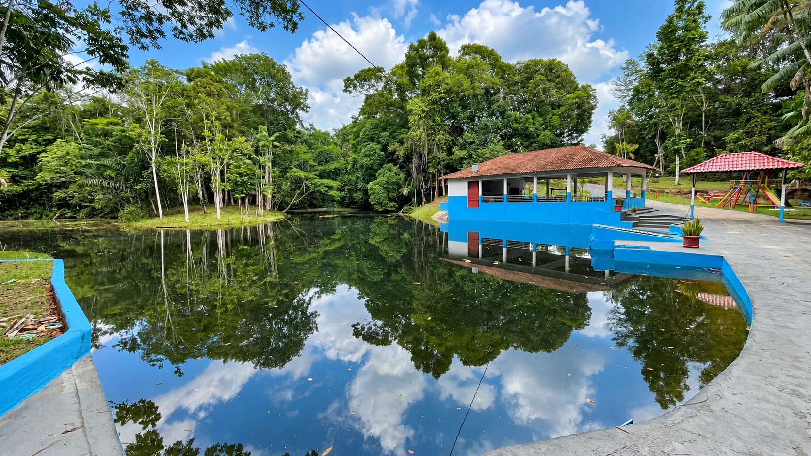 Salão azul refletido na água em meio às árvores